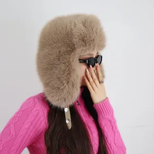 Seitenansicht der flauschigen khakifarbenen Pelzmütze aus Kunstpelz mit rosa Pullover.