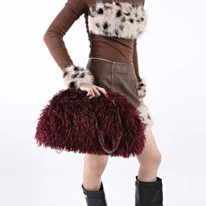 Detail view of large burgundy faux fur cloud bag with elegant gold chain strap