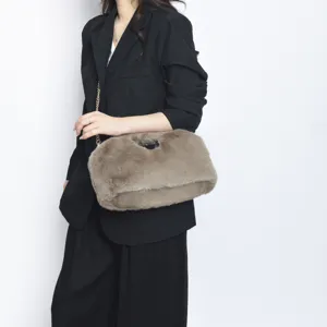 Λεπτομερής προβολή κομψής καφέ τσάντας clutch από συνθετική γούνα με χρυσή αλυσίδα