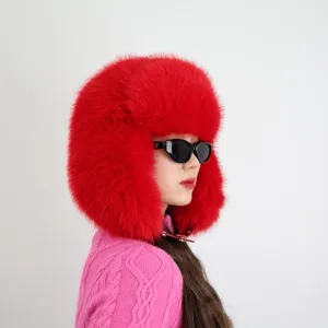 Detailaufnahme einer roten Kunstpelz-Trapper-Mütze an einem Modell für Y2K-Winterlook.