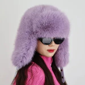 Nahaufnahme einer lila Kunstpelz-Uschanka auf einem weiblichen Model für den Winterskifahren