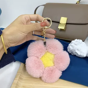 Nahaufnahme eines pink-gelben Plüsch-Blumenanhängers aus Nerzfell an einer Handtasche.