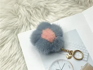 Close-up of fluffy grey and pink mink fur flower keychain with gold heart charm