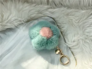 Detailed macro view of soft mint green mink fur flower keychain with gold heart charm