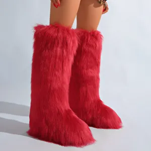 Gros plan sur des bottes de neige rouges en fausse fourrure de renard, chaudes et épaisses.