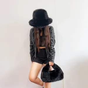 Close-up of black faux fox fur bucket hat and matching hobo bag set on model.