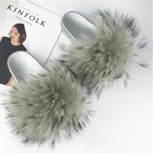 Close-up detail of the plush raccoon fur texture on these silver PVC sole summer slippers