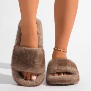 Gros plan de chaussons en fausse fourrure marron portés par un mannequin femme élégant