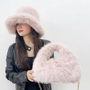 Detail of pink faux fox fur bucket hat and matching hobo bag set on model