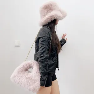 Side view of model wearing pink faux fur bucket hat and matching chain hobo bag