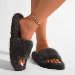 Gros plan détaillé de pantoufles en fausse fourrure gris foncé portées par le mannequin
