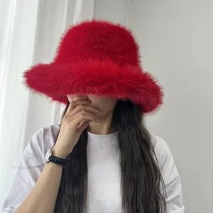 Gros plan d'un modèle portant un chapeau bob en fausse fourrure de renard rouge vif