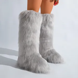 Gros plan de bottes de neige grises en fausse fourrure hauteur genou, texture douce.