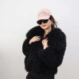 Vista detallada de una chaqueta corta de pelo sintético negro con gorra rosa de moda.