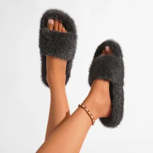 Détail de chaussons en fausse fourrure gris foncé de style punk Y2K portés aux pieds