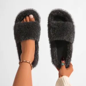 Gros plan de claquettes en fausse fourrure gris foncé avec une esthétique punk Y2K tendance