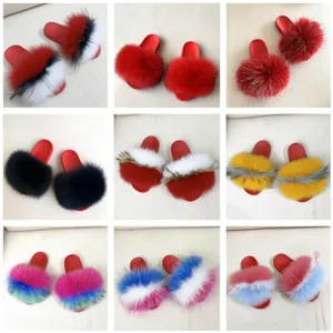 Esposizione di nove pantofole colorate in vera pelliccia con suole in PVC rosso antiscivolo