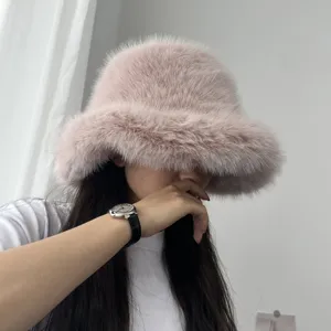 Détail d'un chapeau de pêcheur en fausse fourrure rose à large bord porté par un mannequin