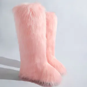 Vue latérale détaillée de bottes roses en fausse fourrure de renard à texture duveteuse