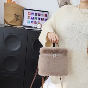 Detailansicht eines weichen braunen Rucksacks aus Pelzimitat, von einem Model gehalten