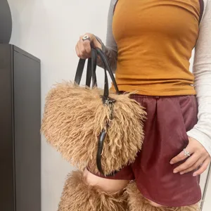 Dettaglio di una borsa tote in pelliccia sintetica marrone con manici in ecopelle.