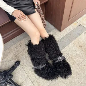 Gros plan de bottes en fausse fourrure noire avec boucles punk sur mannequin.