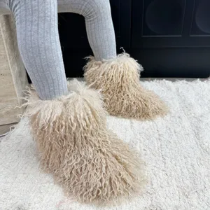 Vue rapprochée de bottes de neige pour enfants en fausse fourrure de mouton beige