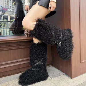 Gros plan sur bottes noires en fausse laine bouclée avec clous argentés et boucle