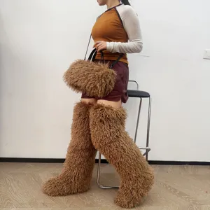Dettaglio di una borsa tote in peluche marrone e stivali sopra il ginocchio coordinati