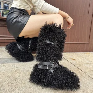 Gros plan de bottes cloutées en fausse laine de mouton noire avec boucles argentées