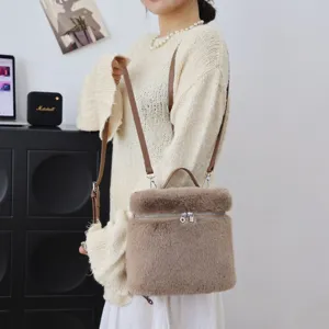 Detailansicht einer weichen braunen Kunstpelz-Umhängetasche an einem Strickpullover