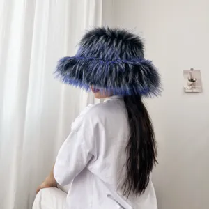 Rückansicht einer Person mit einem flauschigen blauen Kunstpelz-Fischerhut im hellen Raum.