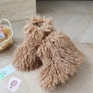 Gros plan montrant la texture douce de la fausse fourrure bouclée des bottes enfant