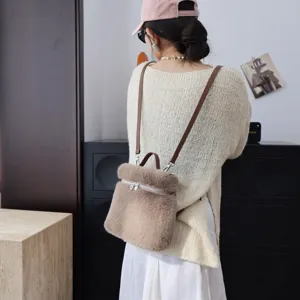 Rückansicht eines Kunstpelz-Rucksacks in Taupe an einem Model mit beigem Pullover
