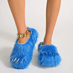 Close-up view of blue furry monster claw slippers featuring metallic spikes and gold chain detail