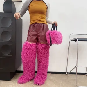 Borsa tote in peluche rosa vivace e stivali in finta pelliccia coordinati in un outfit fashion.