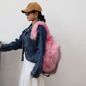 Detailed side view of a stylish pink faux raccoon fur backpack worn with a denim jacket