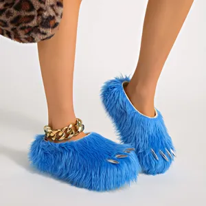 Blue faux fur claw slippers with metallic spikes shown on feet in a detailed view