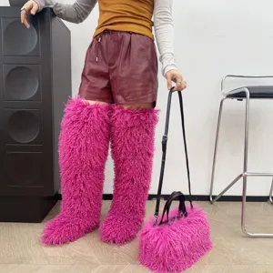 Primo piano di una borsa tote in peluche rosa vivace con stivali pelosi abbinati.