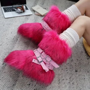 Dettaglio di stivali Y2K in ecopelliccia rosa vibrante con borchie punk e cinturini fibbia.