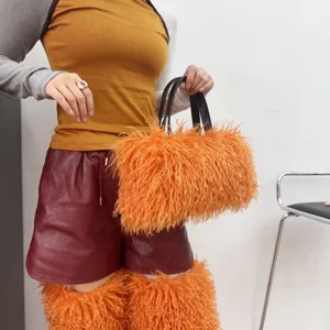 Borsa tote in peluche di lana sintetica arancione tenuta da una modella in abiti autunnali