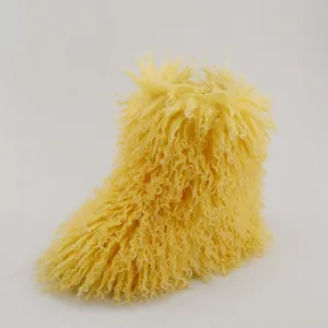 Gros plan sur des bottes de neige jaunes en fausse fourrure pour enfants, texture bouclée