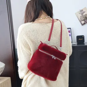 Rückansicht eines roten Kunstpelz-Rucksacks kombiniert mit einem cremefarbenen Strickpullover