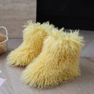 Détail du faux pelage bouclé jaune vif sur des bottes de neige douillettes pour enfants