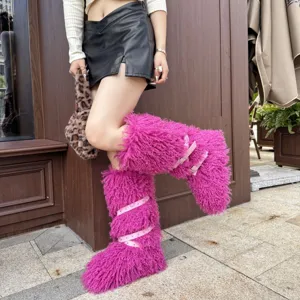 Bottes plates rose vif en fausse laine de mouton avec sangles cloutées