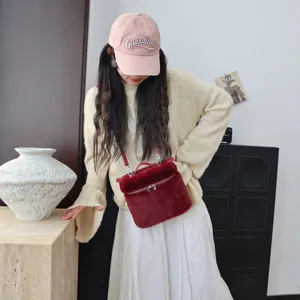 Nahaufnahme einer roten Umhängetasche aus Kunstpelz, kombiniert mit einem hellen Pullover.