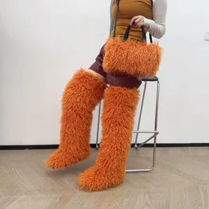 Vista dettagliata della trama pelosa di una borsa tote in ecopelliccia arancione e stivali