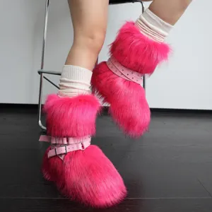 Dettaglio di stivali da neve rosa fluo in ecopelliccia con cinturini punk borchiati e soffici