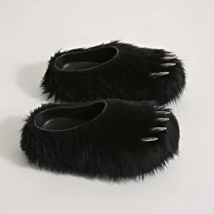 Close-up detail of black faux fur claw mule slippers featuring metallic spike design.