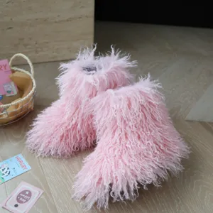 Gros plan des bottes pour enfants en fausse fourrure rose montrant la texture douce.